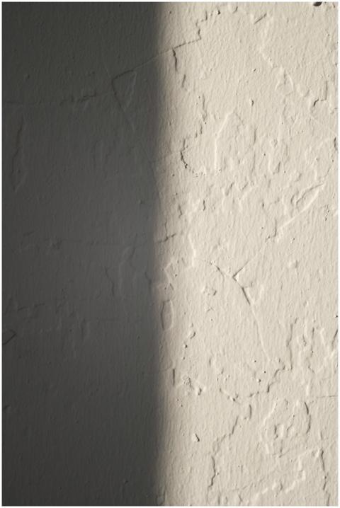 Close-up of a textured plaster wall with light and