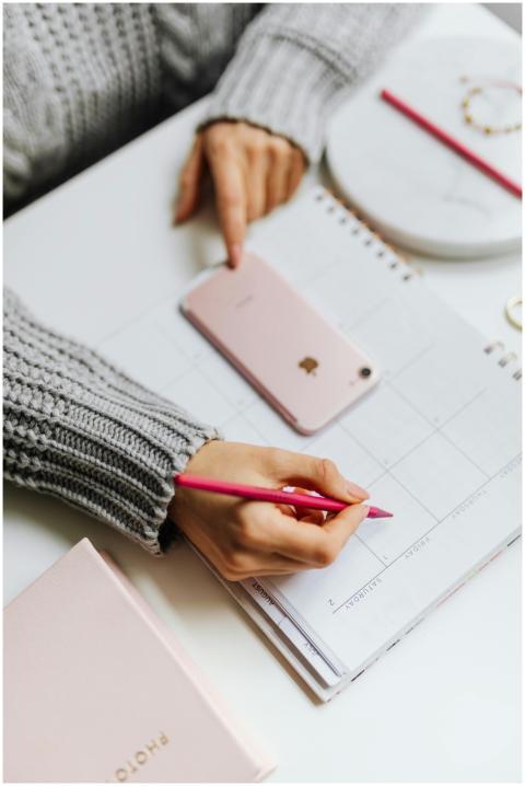 Close-up of a woman planning on a calendar using a