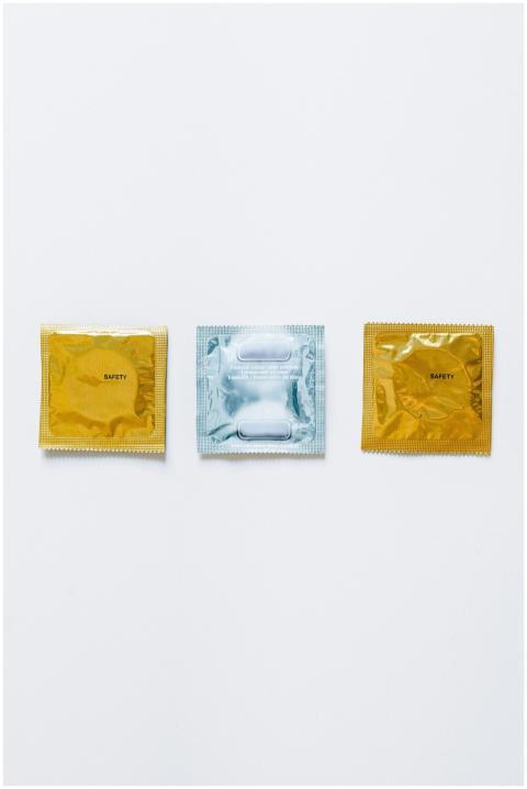 Three condom packages on a white background symbol
