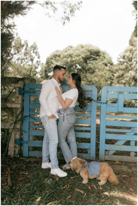 Young couple in casual wear embracing beside blue