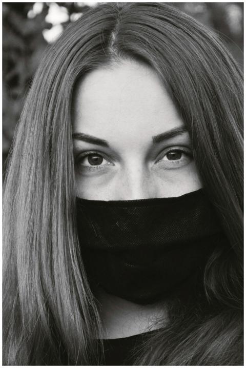 Black-and-white portrait of a woman wearing a face