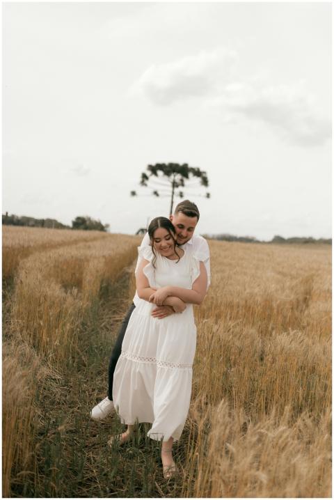 A young couple embracing romantically in a wheat f