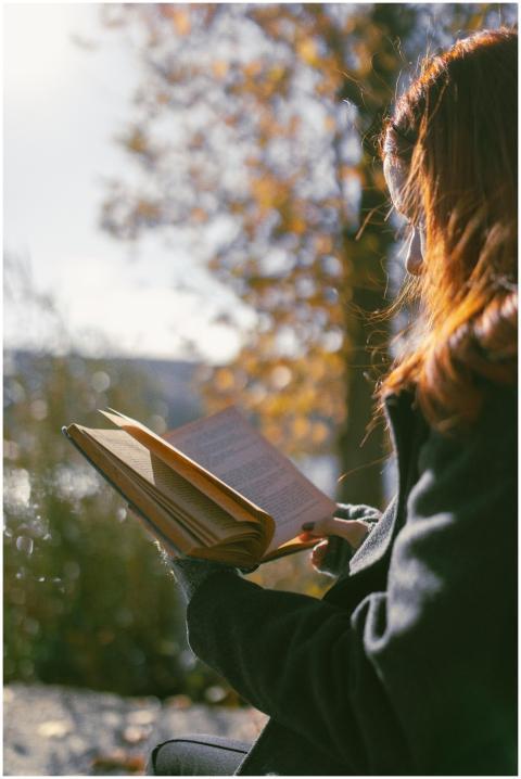 A woman enjoys reading a book outdoors in Ankara d