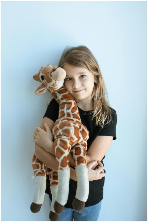 A smiling girl wearing a black shirt embraces a gi