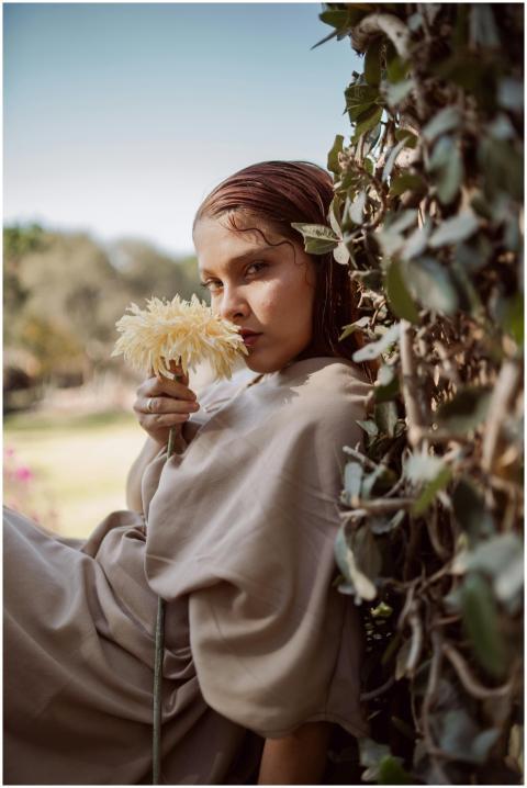 A serene portrait of a woman holding a flower by l