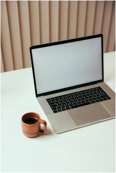 A minimalist workspace with a laptop and a cup of