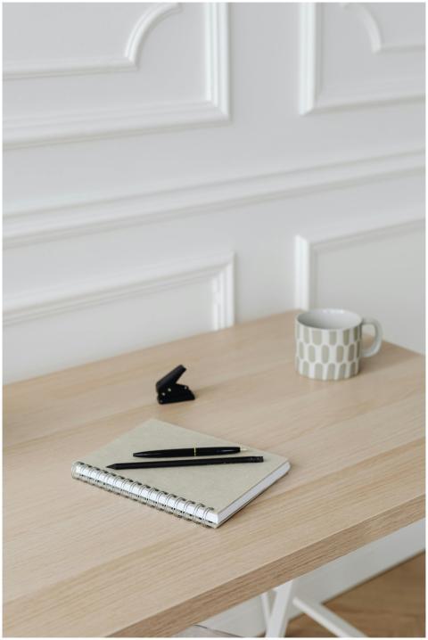 A clean, minimalist office setup featuring a noteb