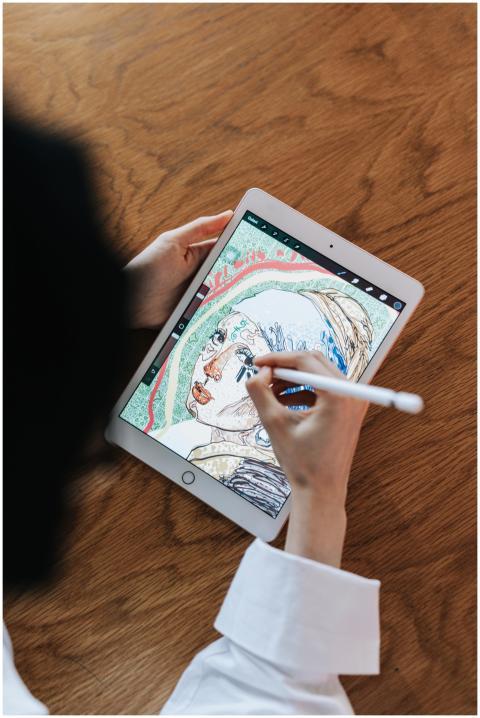 Woman drawing digital artwork on a tablet using a