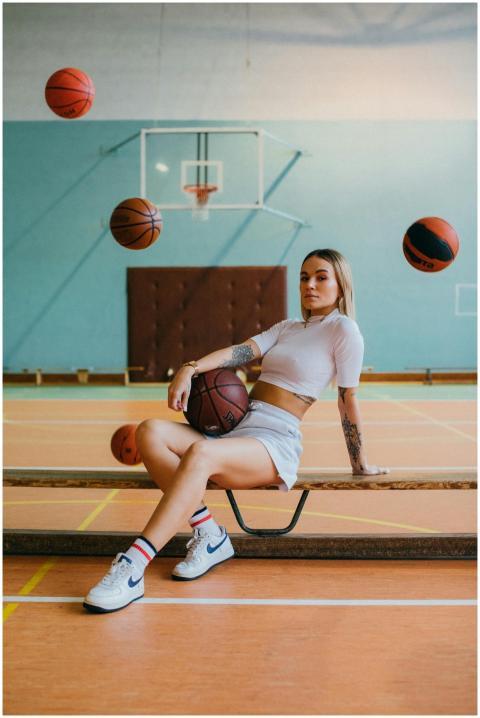 Stylish woman sitting on a bench in a sports hall