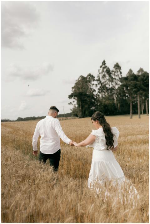 A couple holding hands and walking through a seren