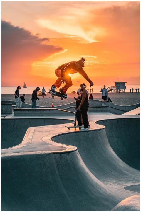 Skateboarder performing an aerial trick at a beach