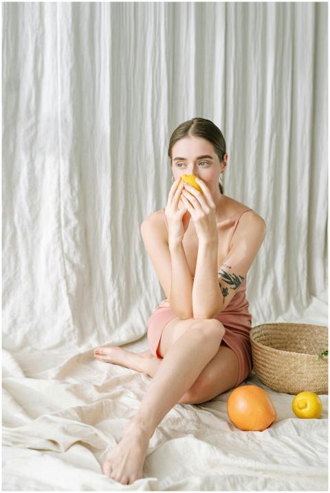 Woman enjoying citrus fruits in a serene, minimali