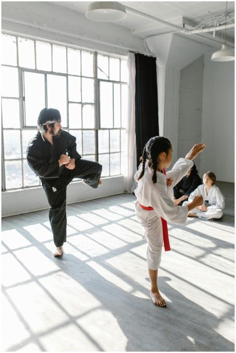 A martial arts class with a girl and an adult prac
