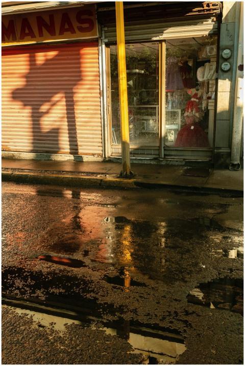 Sunlit urban scene with storefront reflection in a