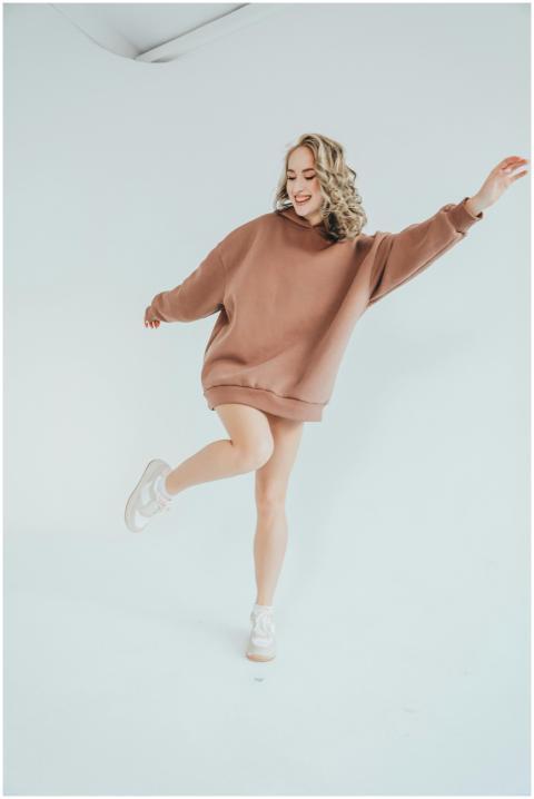 Fashionable woman in oversized hoodie striking a p