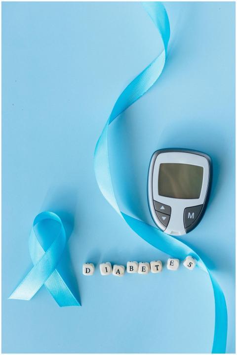 Flat lay of a blood glucose meter and ribbon symbo