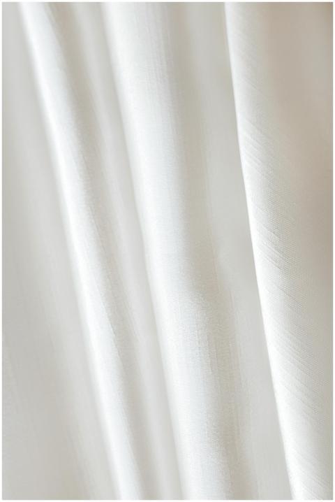 Detailed close-up of a white fabric with soft, flo