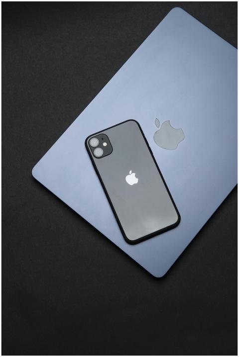 Modern Apple iPhone and MacBook on black surface,