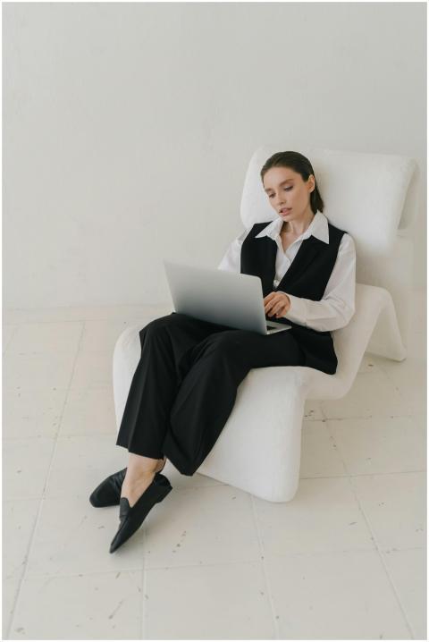 Stylish businesswoman in suit working on laptop in