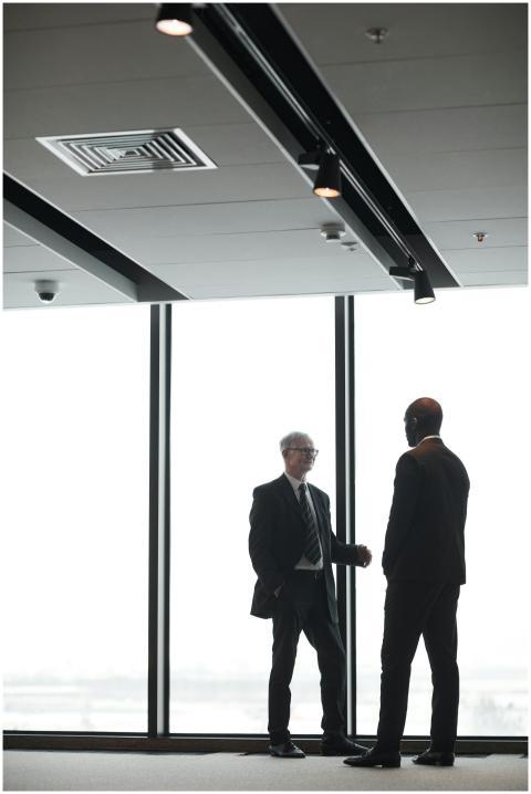 Two corporate executives in formal attire discuss