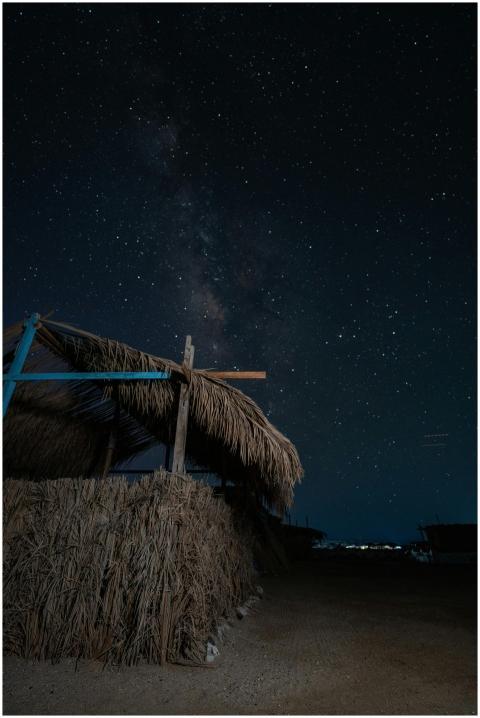 A serene night sky filled with stars over a rustic