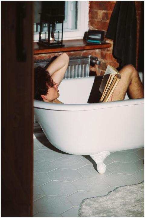 Young adult enjoying a relaxing bath with a book i