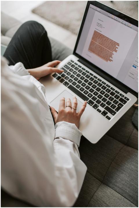 Woman working on a laptop indoors, focusing on doc