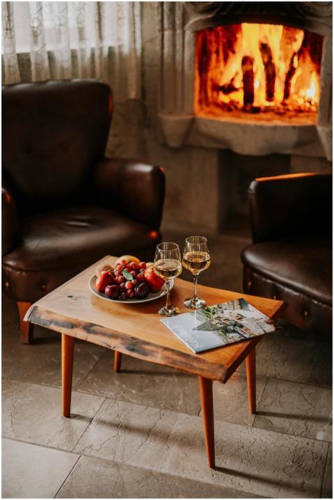 Warm indoor setting with wine and fruit near a fir