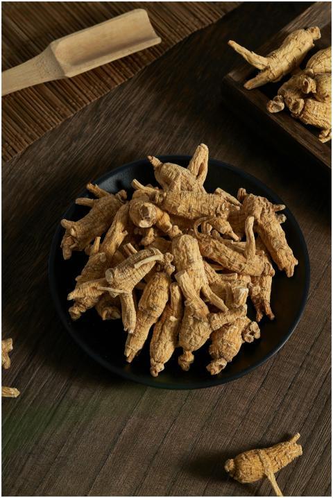 Detailed shot of dried ginseng roots on a dark pla