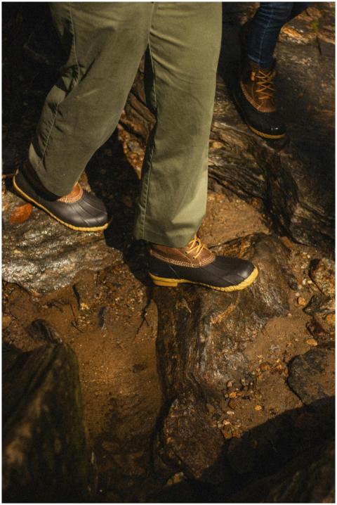 Close-up of two people hiking on rocky terrain wit