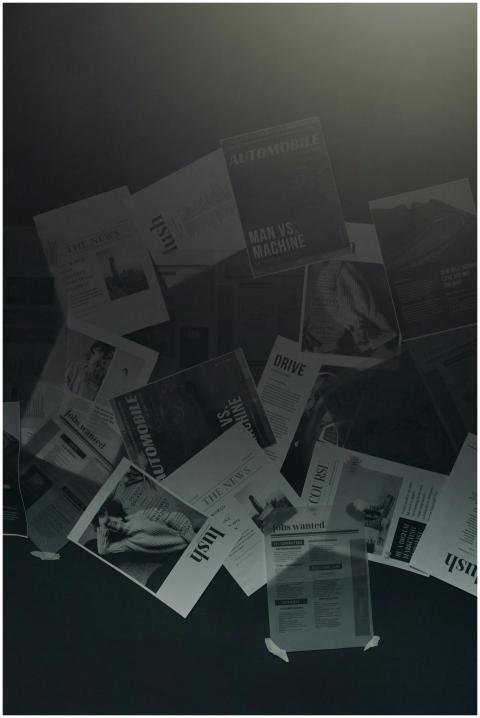 Papers with headlines floating against a dark back