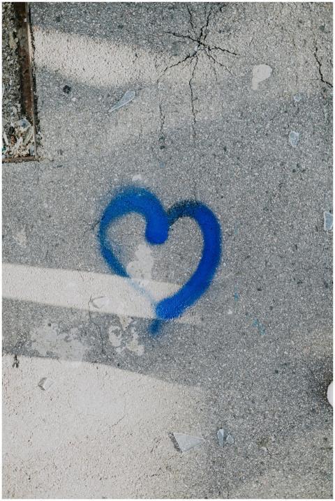Artistic blue heart graffiti painted on a concrete
