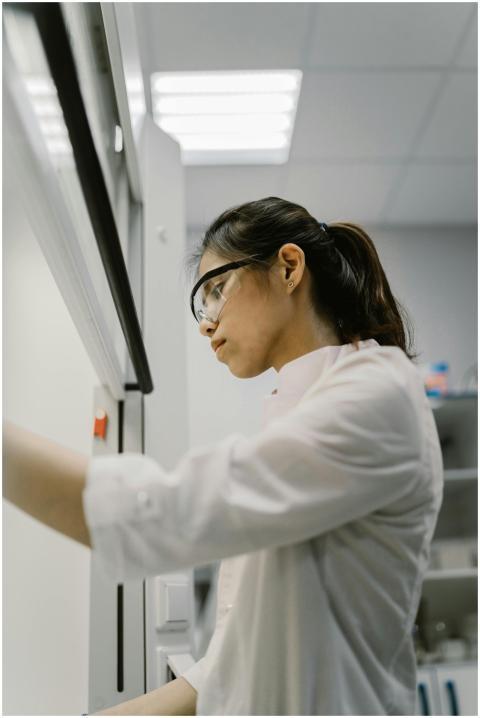 Side view of a female scientist in a lab coat work