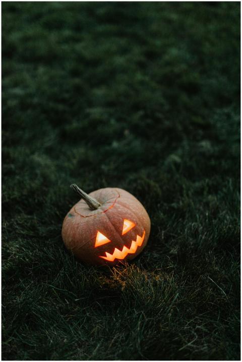 A spooky carved pumpkin glowing in the dark, perfe