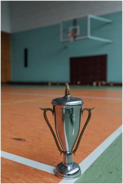 Silver trophy placed on an indoor basketball court