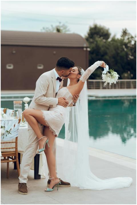 Bride and groom in an intimate kiss by the poolsid