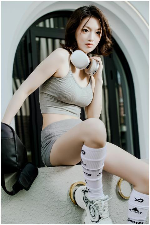 Stylish young woman wearing athletic outfit, posin