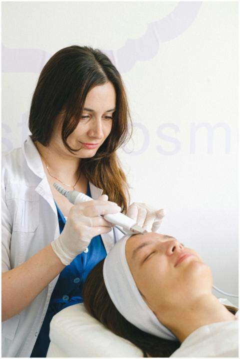 A beautician performs a facial treatment on a clie