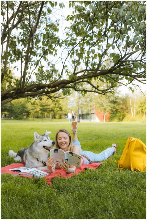 Woman reading a magazine with her Siberian husky o