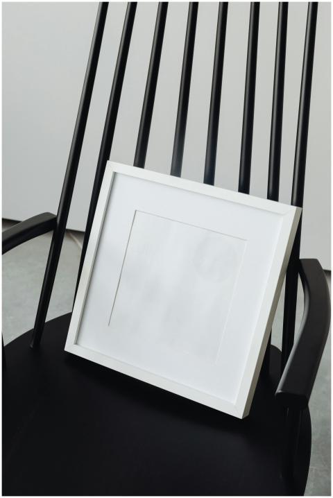 Simple black chair with a blank white picture fram