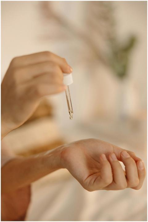 Close-up image of a hand using a dropper to apply