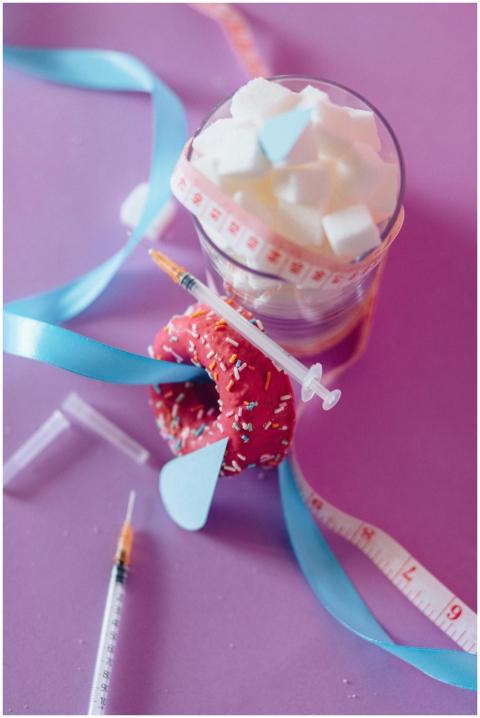 Conceptual image with sugar cubes, syringe, and ri