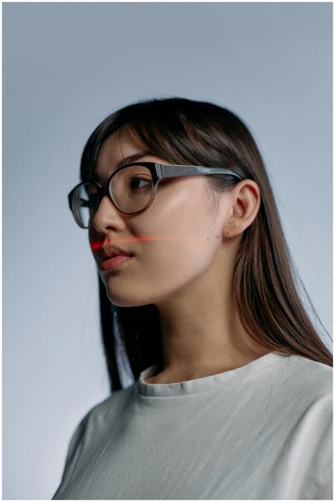 Side profile of a woman with eyeglasses and laser