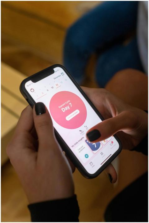Close-up of a woman using a menstrual tracking app