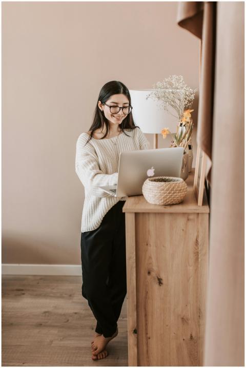 A woman in casual clothing using a laptop at home,