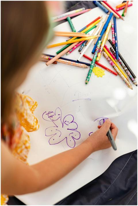A child creatively drawing with colored pencils at