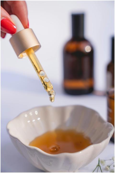 A dropper releasing liquid into a bowl with blurre
