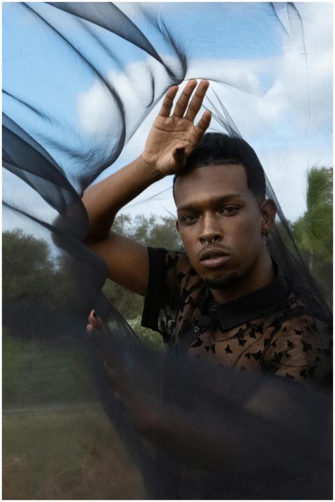 Artistic portrait of a man posing with a flowing b