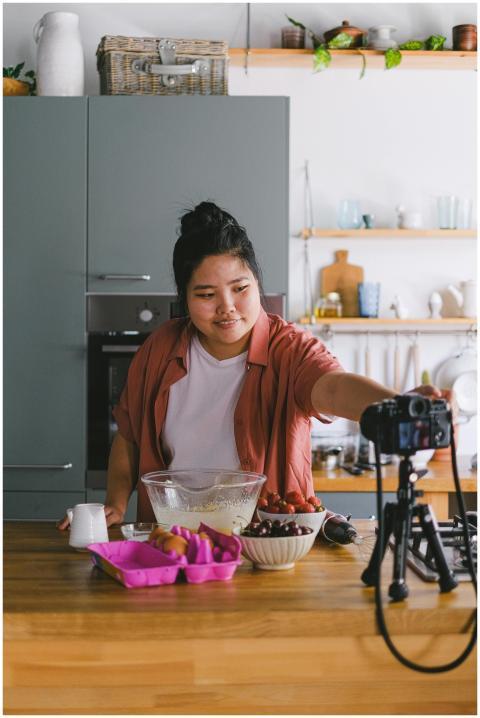 A woman filming a cooking tutorial in a modern kit