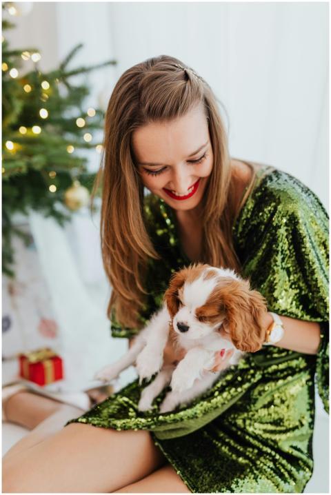 Joyful woman in festive dress holding a puppy by C